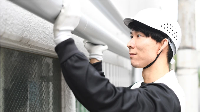 屋外水回りの確認をしている男性従業員